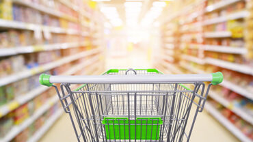 Supermarket aisle product shelves interior blur background with